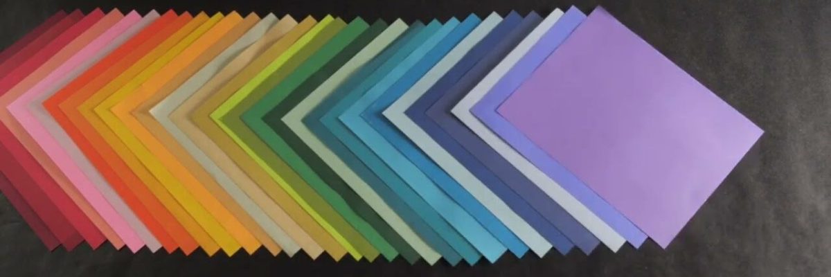 a row of sheets of colored paper overlapping one another on a black background